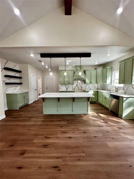 Spacious kitchen featuring wood-finish flooring, vaulted ceilings with an exposed beam, and recessed lighting