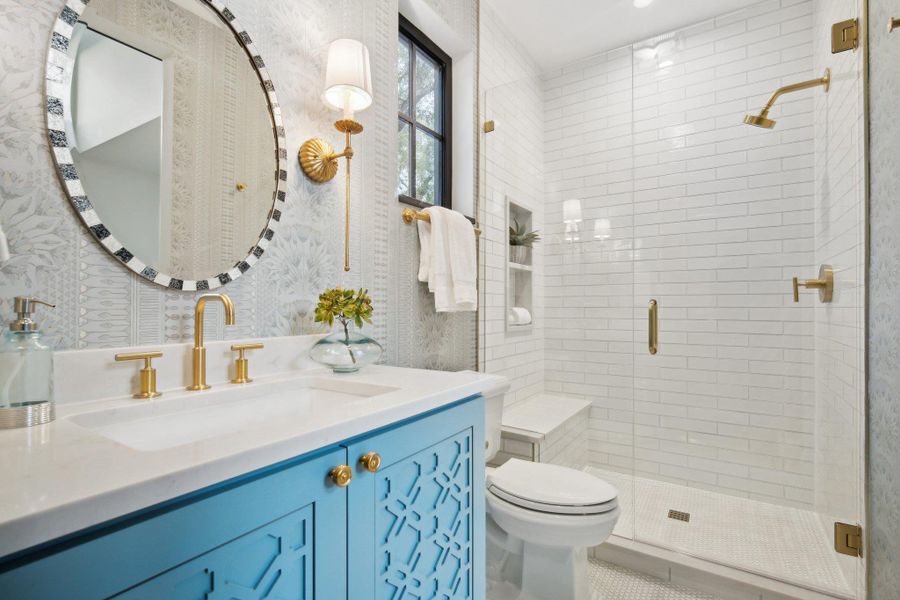 Full bath with tile patterned floors, toilet, a shower stall, wallpapered walls, and vanity