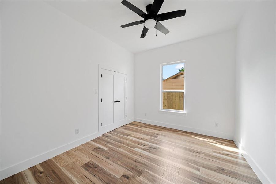 Empty room with light hardwood / wood-style floors and ceiling fan