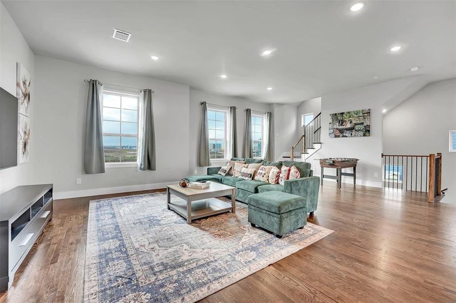 Living room with dark wood-style flooring and recessed lighting