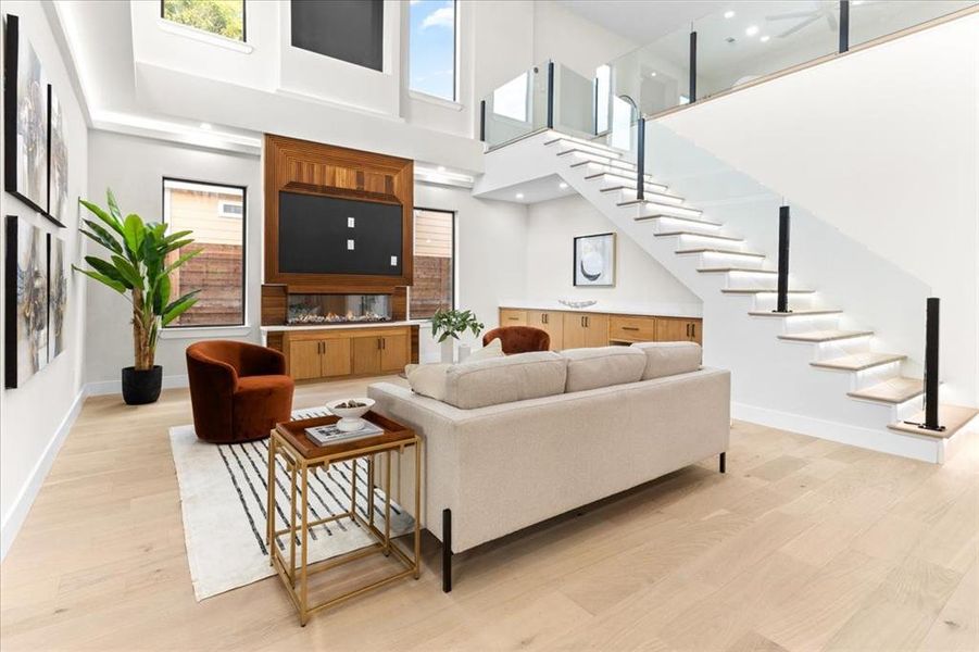 Living room featuring light hardwood / wood-style flooring and a high ceiling