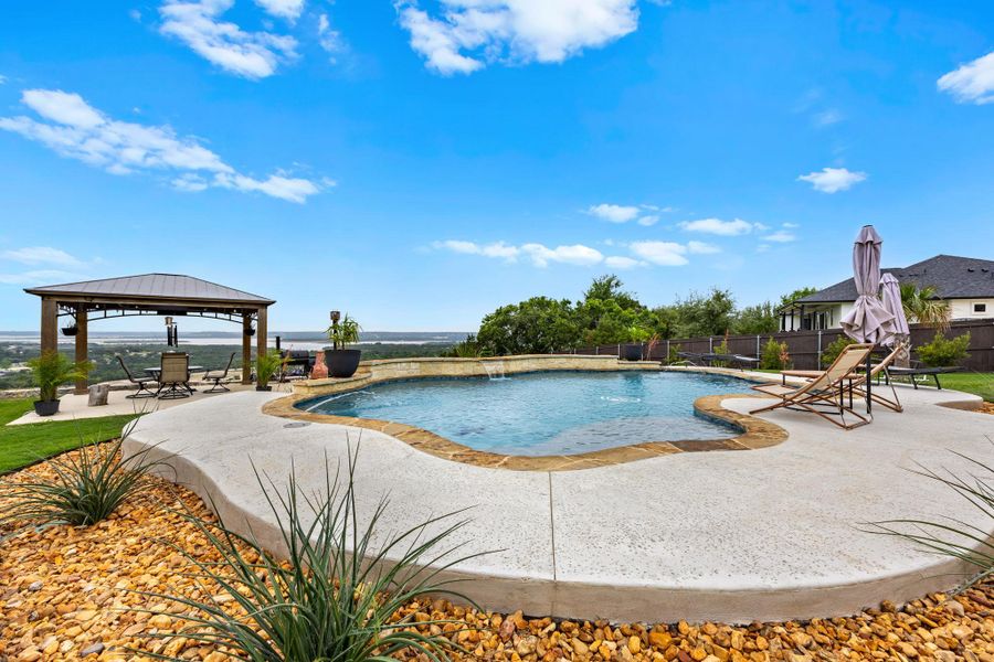 An inviting backyard oasis offers a sparkling pool and a covered pergola, all against a panoramic view. An inviting backyard oasis offers a sparkling pool and a covered pergola, all against a panoramic view.