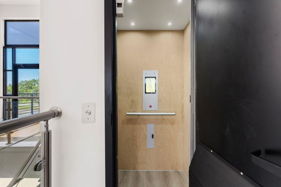 A residential elevator with a warm paneled interior provides easy access between floors — a meaningful amenity that makes this home functional for a wide range of buyers and life stages.