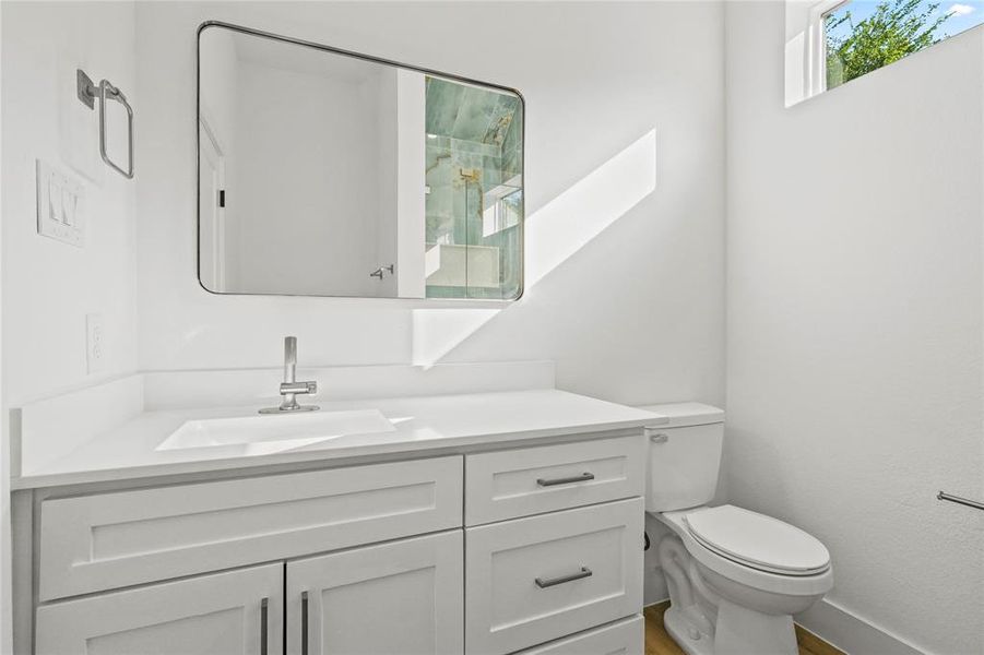 Half bathroom featuring vanity and toilet