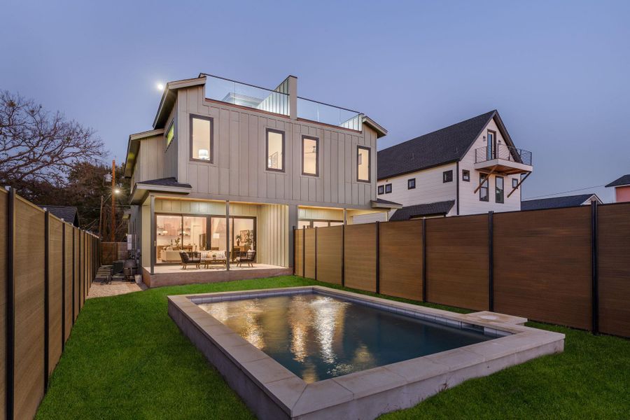 Back of house with board and batten siding, a fenced backyard, and a patio area