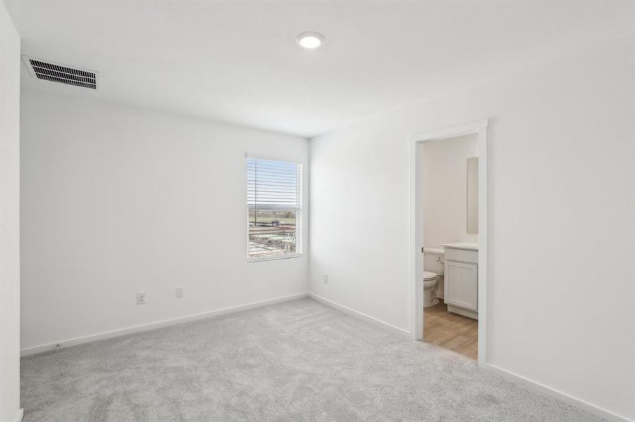 Neutral-toned room featuring a single window with blinds, recessed ceiling lighting, and light gray carpet