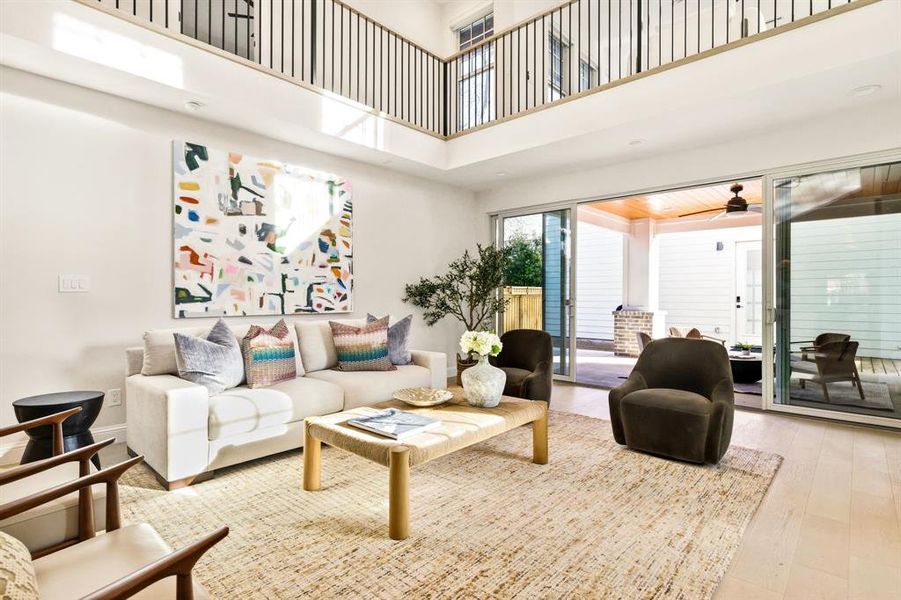 Living area featuring a high ceiling, wood finished floors, and a ceiling fan