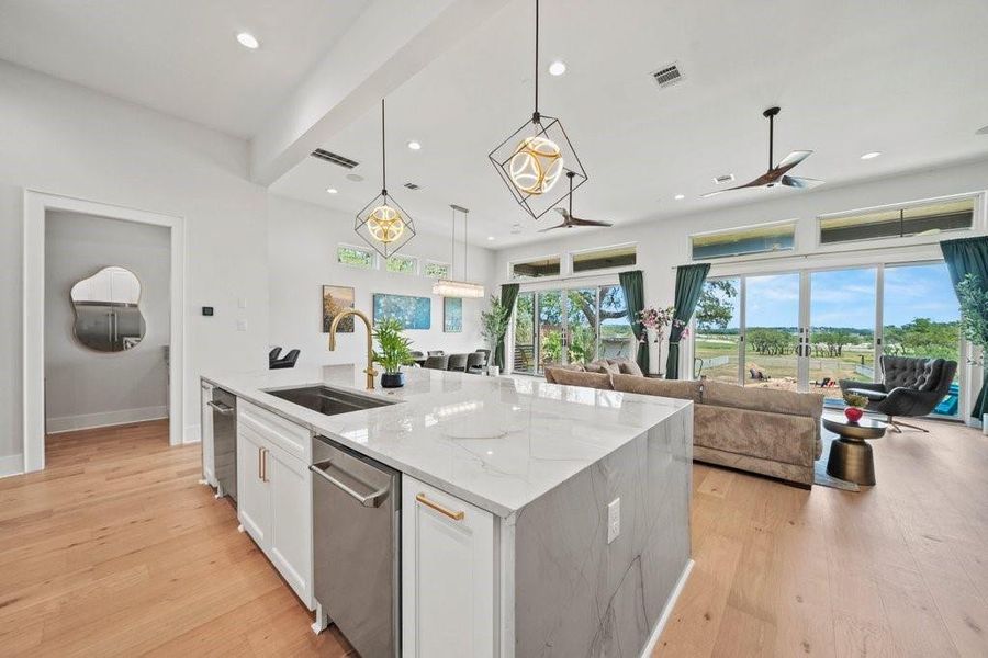 Enjoy breathtaking views from this sleek, open-concept kitchen featuring a waterfall-edge island, modern pendant lighting, and seamless flow into the bright living area. Ideal for entertaining or everyday luxury near Canyon Lake.