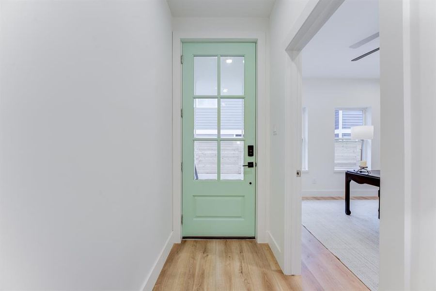 The front entryway features recessed lighting, luxury vinyl plank flooring, and a full bedroom and ensuite bathroom to the left of the doorway.