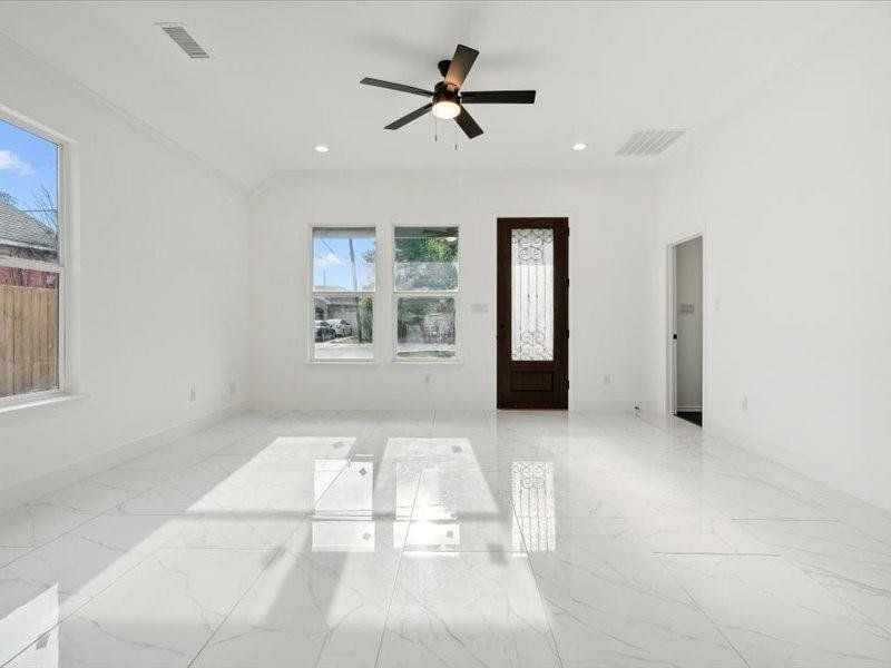 Spare room with ceiling fan and light tile patterned floors