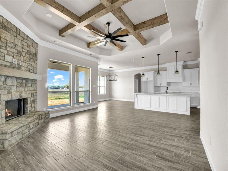 Unfurnished living room with wood finish floors, baseboards, a fireplace, and ceiling fan Unfurnished living room with wood finish floors, baseboards, a fireplace, and ceiling fan