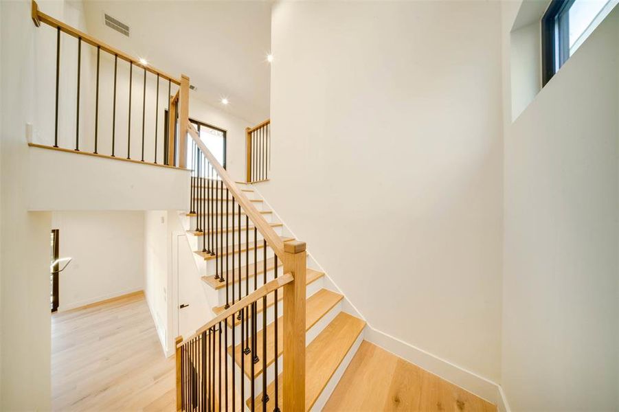 Stairway featuring a healthy amount of sunlight and wood-type flooring