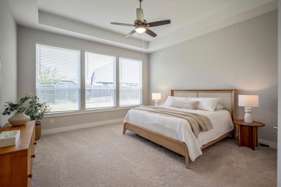 You’ll have sweet dreams in this luxe owner’s suite with soft neutral carpet and paint, a wall of windows overlooking the backyard, a raised tray ceiling with a cooling fan and plenty of room to stretch out and relax.