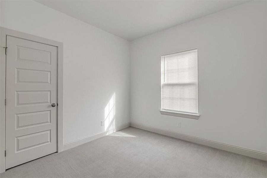Spare room with light carpet and baseboards