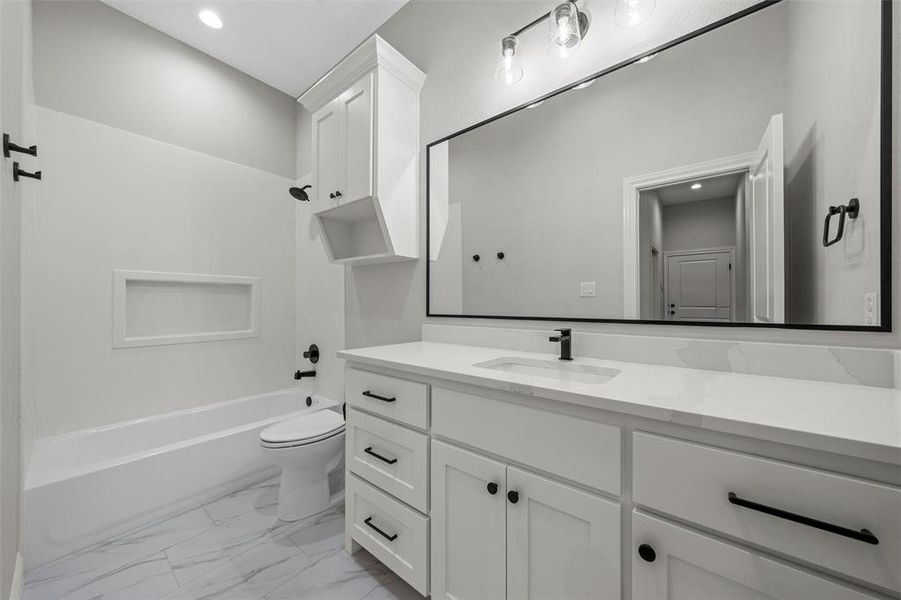 Bathroom featuring vanity, bathing tub / shower combination, recessed lighting, and light marble finish floors Bathroom featuring vanity, bathing tub / shower combination, recessed lighting, and light marble finish floors