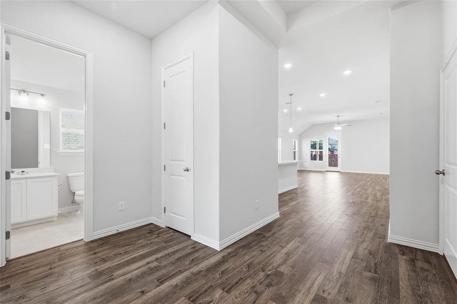 Spacious open-concept interior featuring wood-finish flooring, vaulted ceilings, and recessed lighting