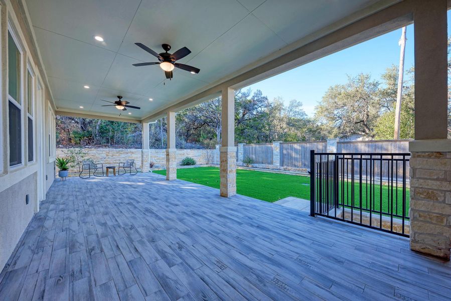 Wooden terrace with a fenced backyard, a ceiling fan, and a patio