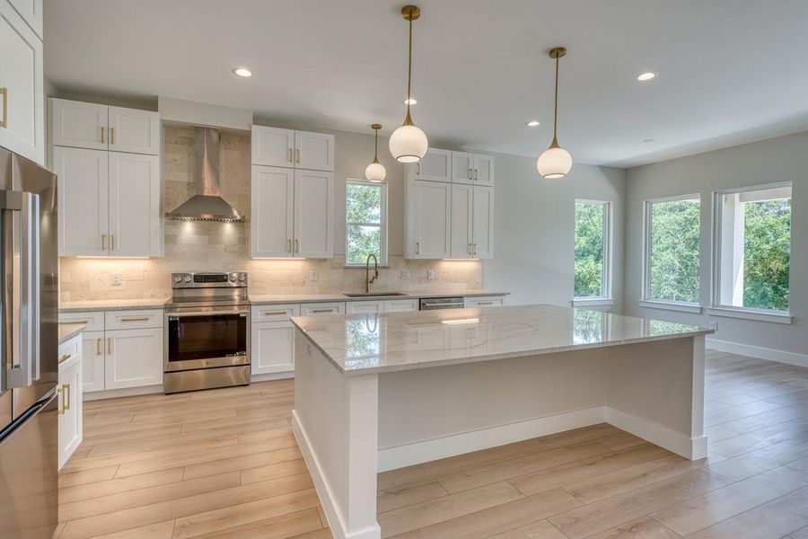 Culinary delights await in this bright kitchen with a spacious island and gleaming stainless steel appliances.