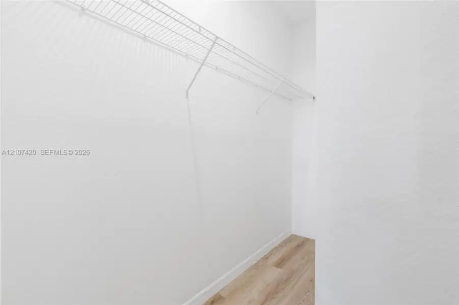 Storage space featuring wood-finish flooring and integrated wire shelving Storage space featuring wood-finish flooring and integrated wire shelving