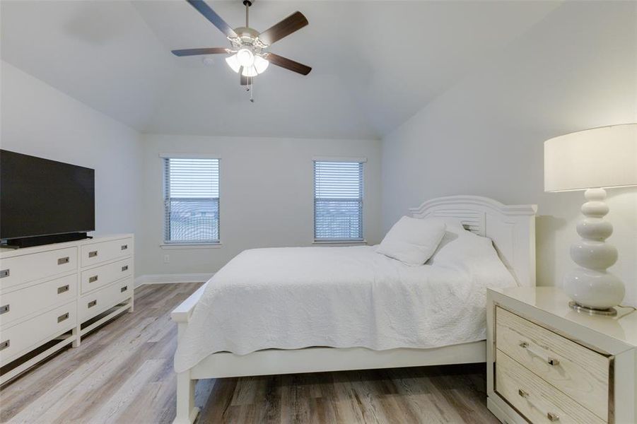 Bedroom featuring ceiling fan, vaulted ceiling, and hardwood / wood-style flooring