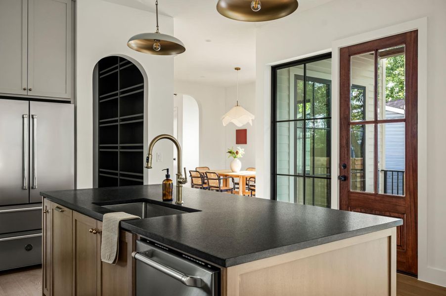 A contemporary kitchen island features a sink, providing a functional focal point within the open-concept living space.