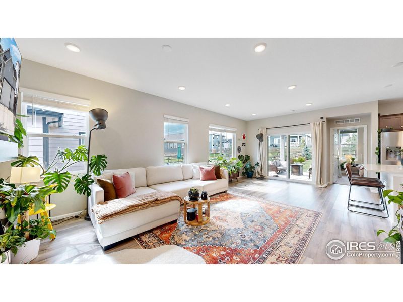 Open concept floor plan featuring LVP flooring, a gas fireplace in the living space and a walk-out patio.