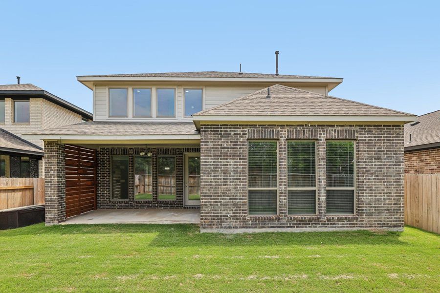 Back of property featuring a patio, brick siding, and a shingled roof Back of property featuring a patio, brick siding, and a shingled roof