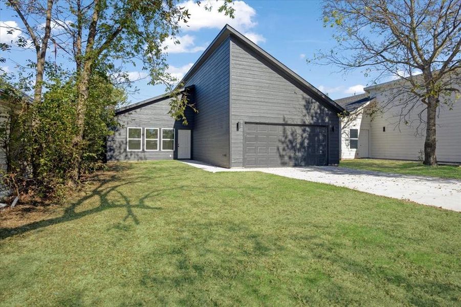 View of home's exterior with a garage and a lawn