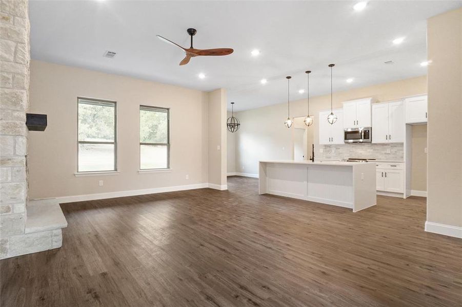 Unfurnished living room with ceiling fan and dark hardwood / wood-style flooring