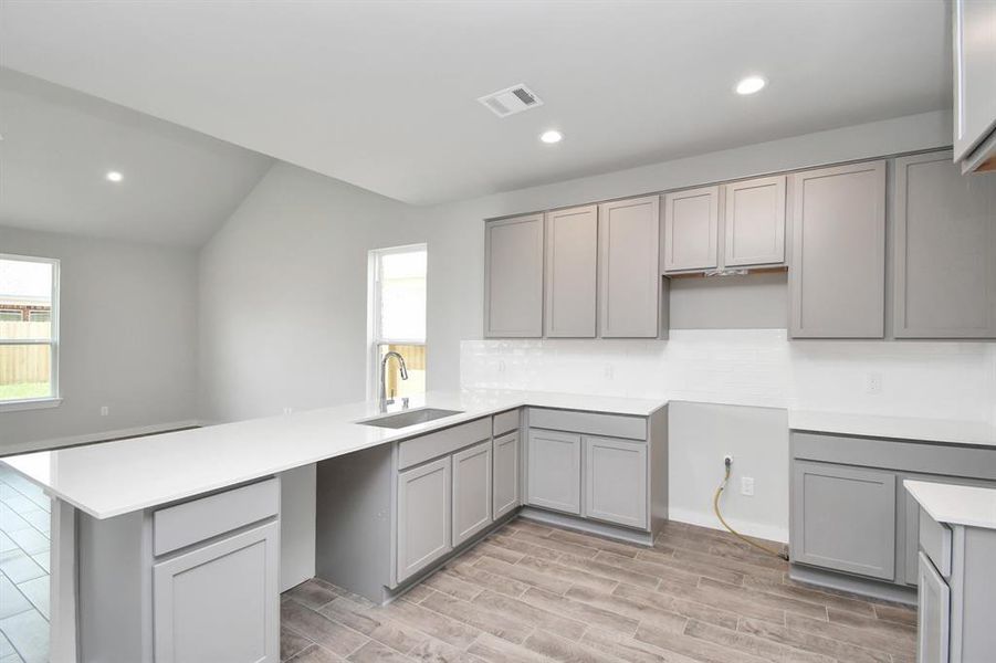 Culinary haven, featuring granite countertops, a tile backsplash, stainless steel appliances (to be installed), and 42” upper cabinets. Sample photo of completed home with same plan. Actual colors and selections may vary.