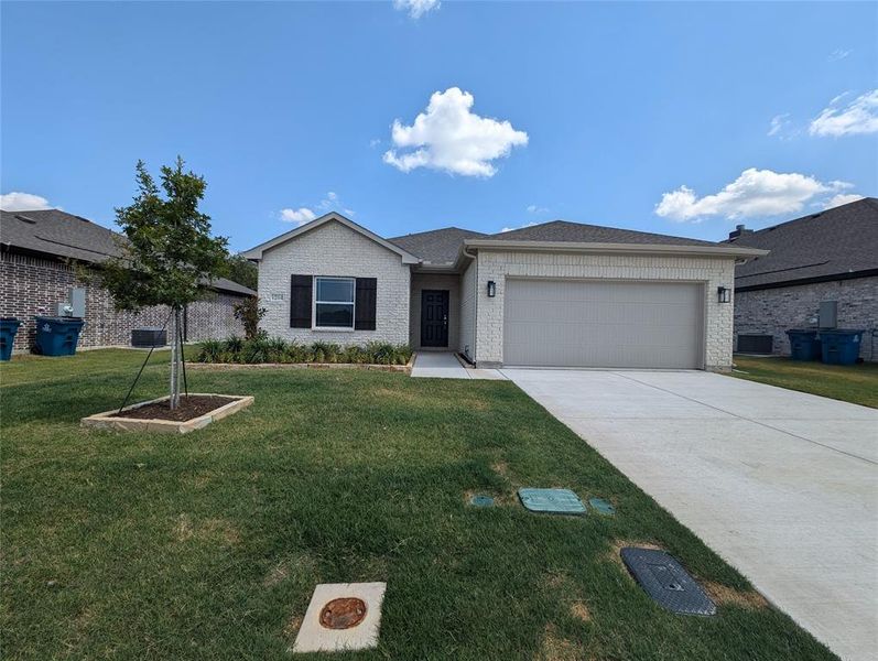 Single story home featuring a garage and a front yard