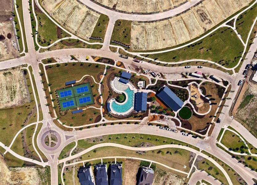 Aerial view highlighting the community's amenities, featuring tennis courts, a swimming pool, and dedicated recreational areas