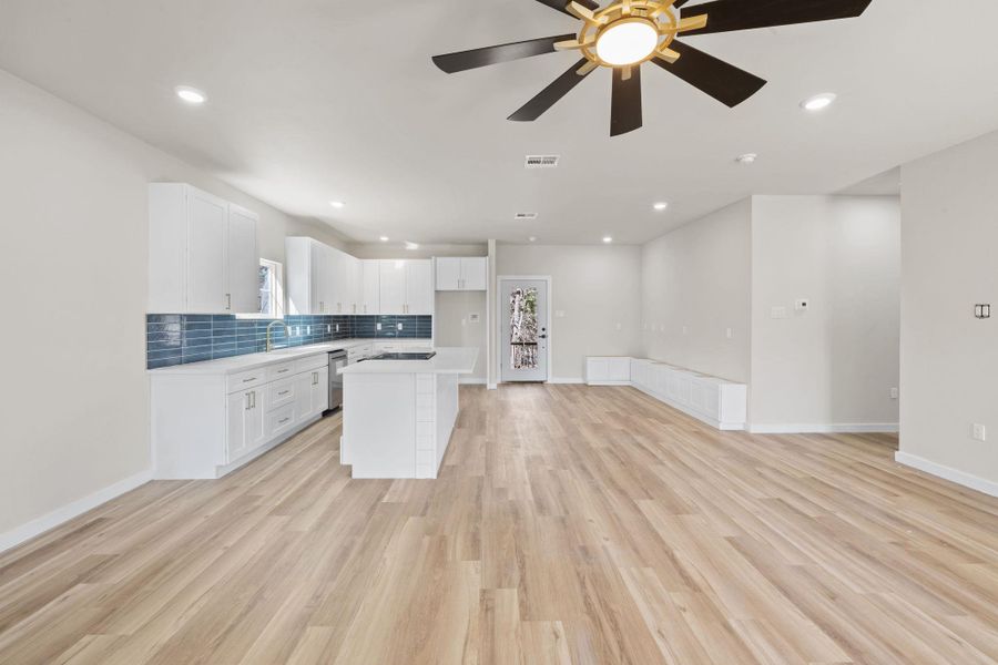 Kitchen featuring white cabinetry, open floor plan, tasteful backsplash, a kitchen island, and recessed lighting Kitchen featuring white cabinetry, open floor plan, tasteful backsplash, a kitchen island, and recessed lighting