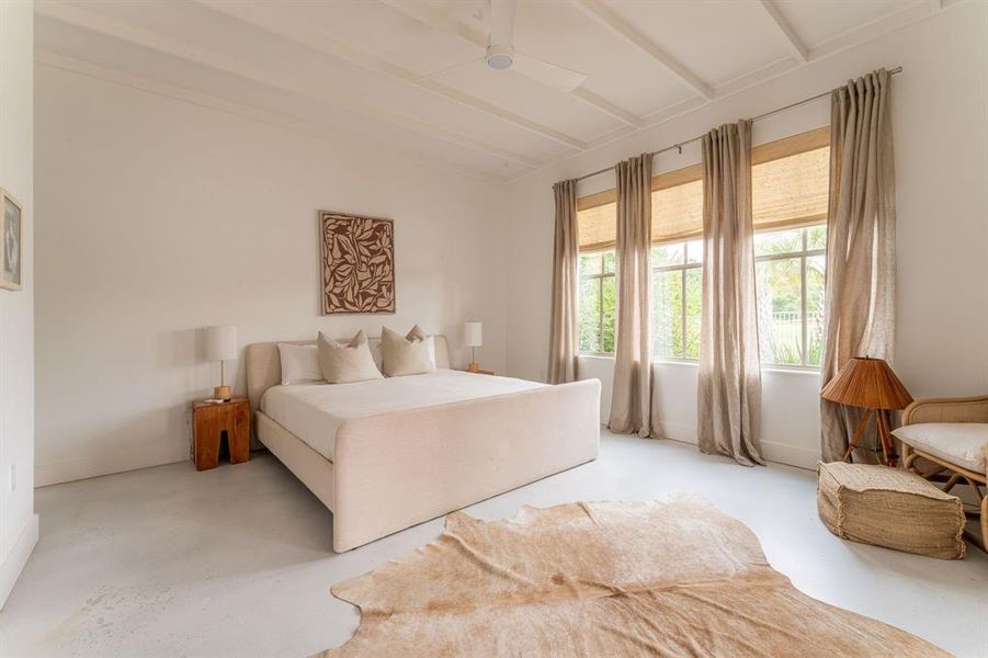 Bedroom with french doors, beamed ceiling, concrete floors, access to outside, and a ceiling fan Bedroom with french doors, beamed ceiling, concrete floors, access to outside, and a ceiling fan