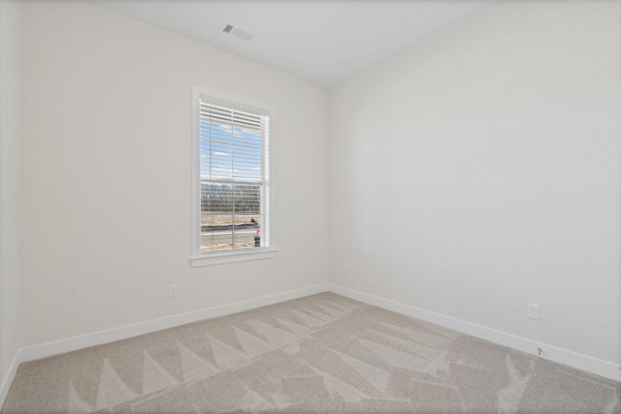 Spare room with baseboards and light colored carpet