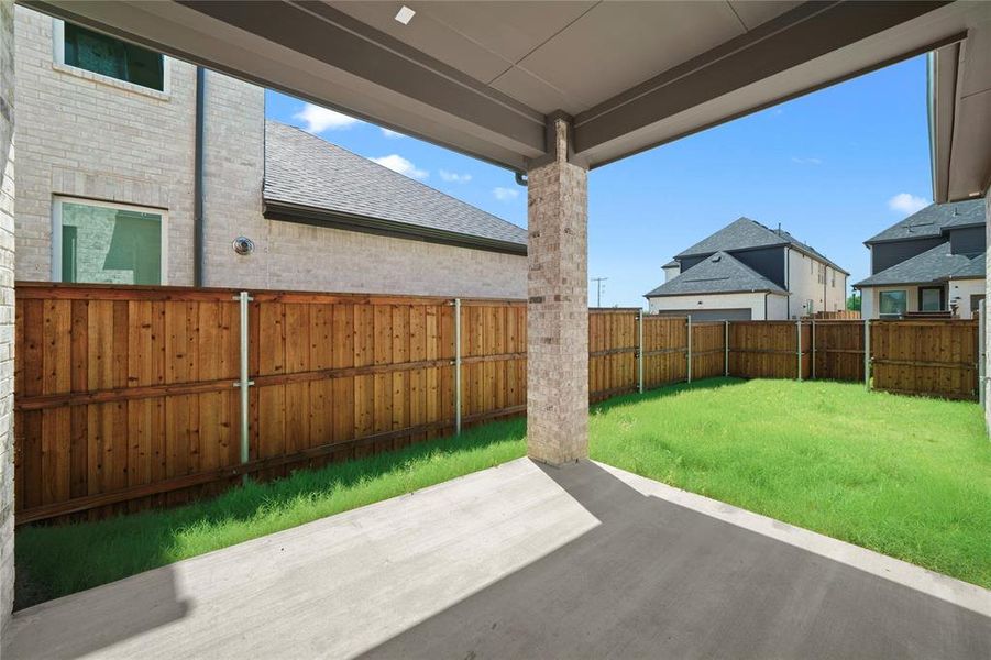 Covered patio area featuring a concrete slab and a stone-clad support pillar