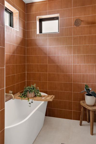 Full bathroom featuring a freestanding bath, tile walls, and tile patterned floors Full bathroom featuring a freestanding bath, tile walls, and tile patterned floors