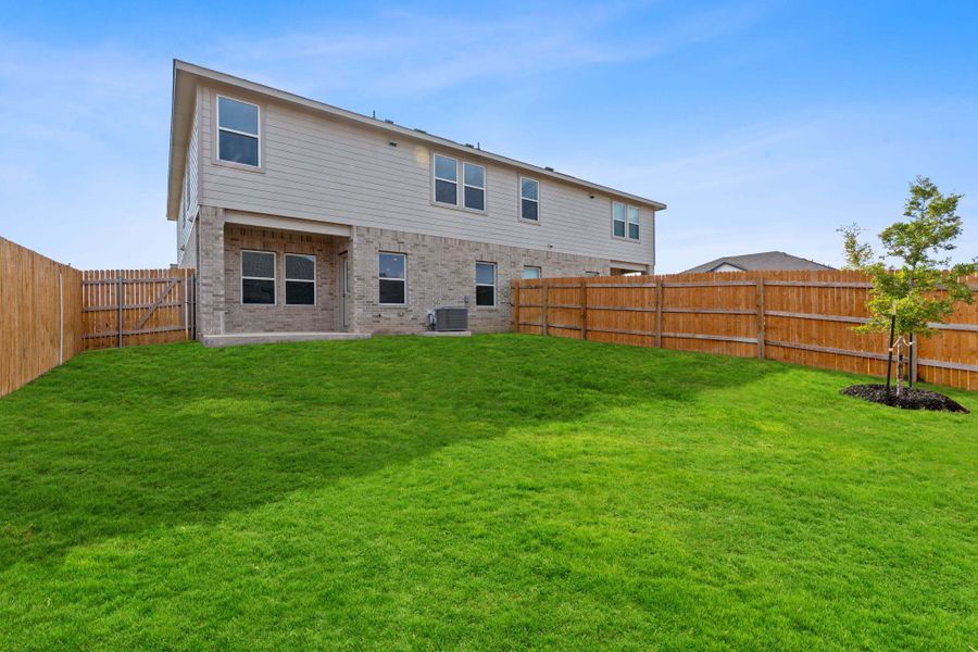 Rear view of property with a fenced backyard and brick siding Rear view of property with a fenced backyard and brick siding