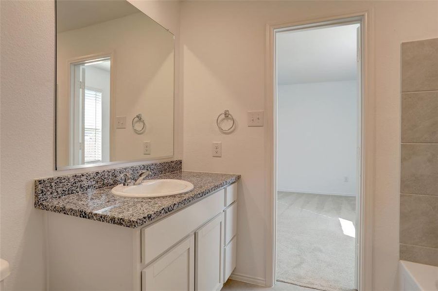 Bathroom with vanity and light carpet