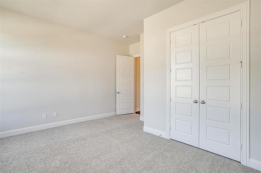 Unfurnished bedroom with a closet and light colored carpet