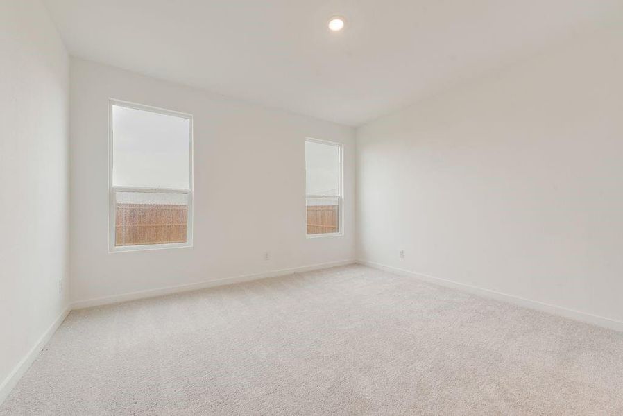 Unfurnished room featuring light carpet and baseboards