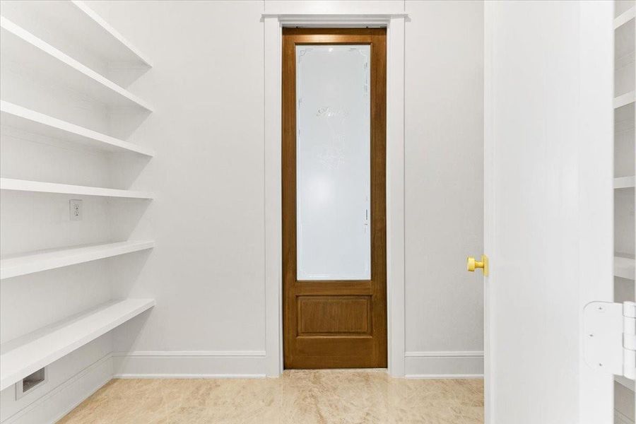 Walk-in pantry with built-in shelving offering exceptional storage and organization. Walk-in pantry with built-in shelving offering exceptional storage and organization.