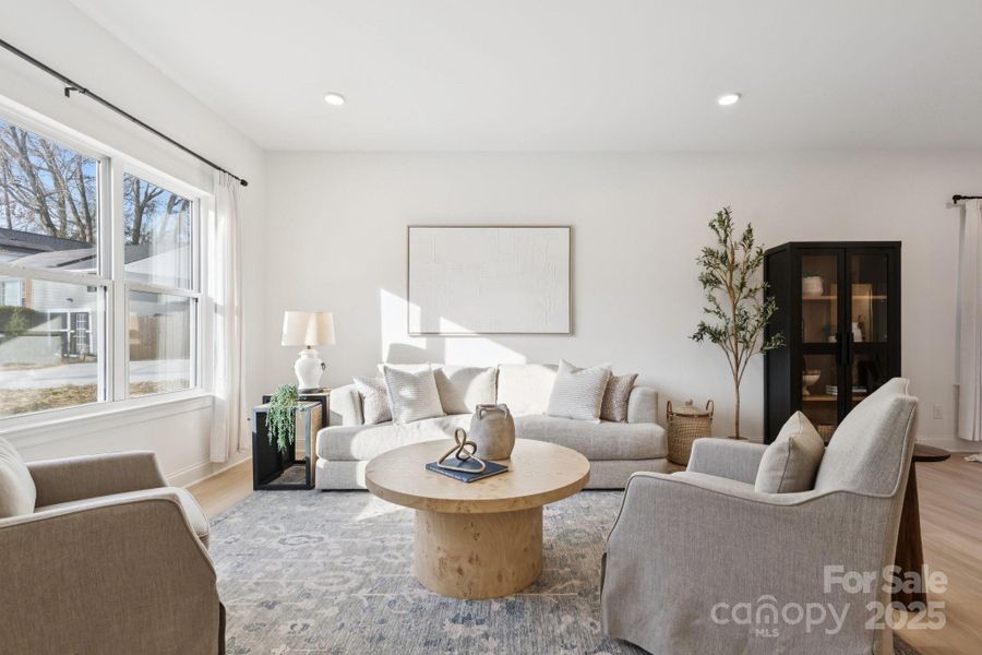 9' ceilings, light oak-colored LVP flooring, recessed lights, and tons of natural light fills this open-concept living space