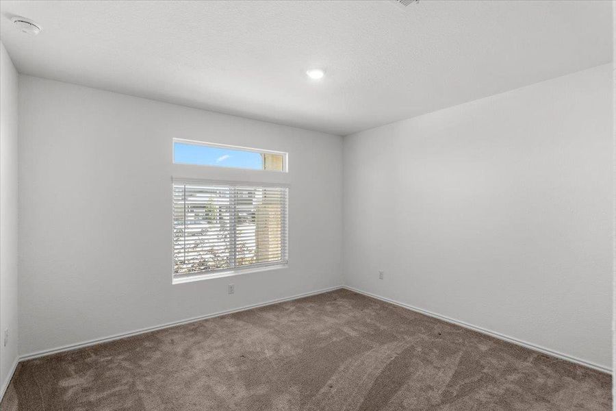 Spare room with dark carpet and a smoke detector