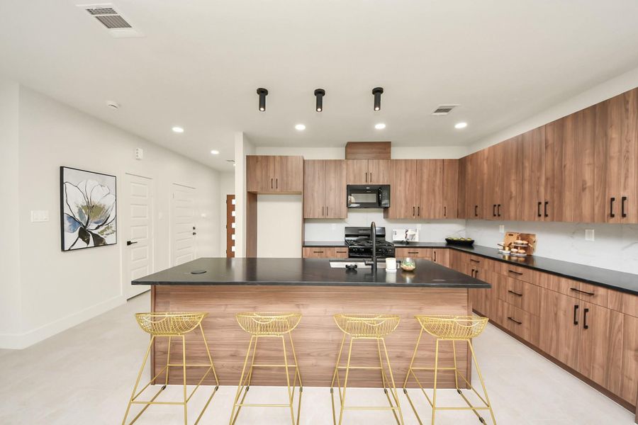 Discover the allure of this sleek, modern kitchen, featuring elegant cabinetry, a spacious island, and contemporary finishes perfect for culinary enthusiasts.