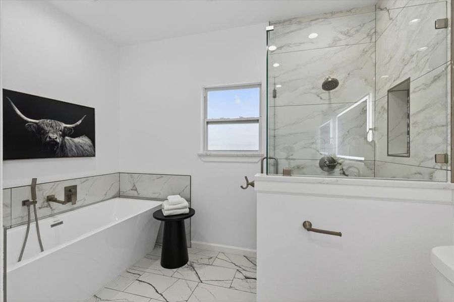 Spa-inspired bathroom featuring a frameless glass shower enclosure with marble-look tile, a separate soaking tub with wall-mounted fixtures, and geometric-patterned floor tile.