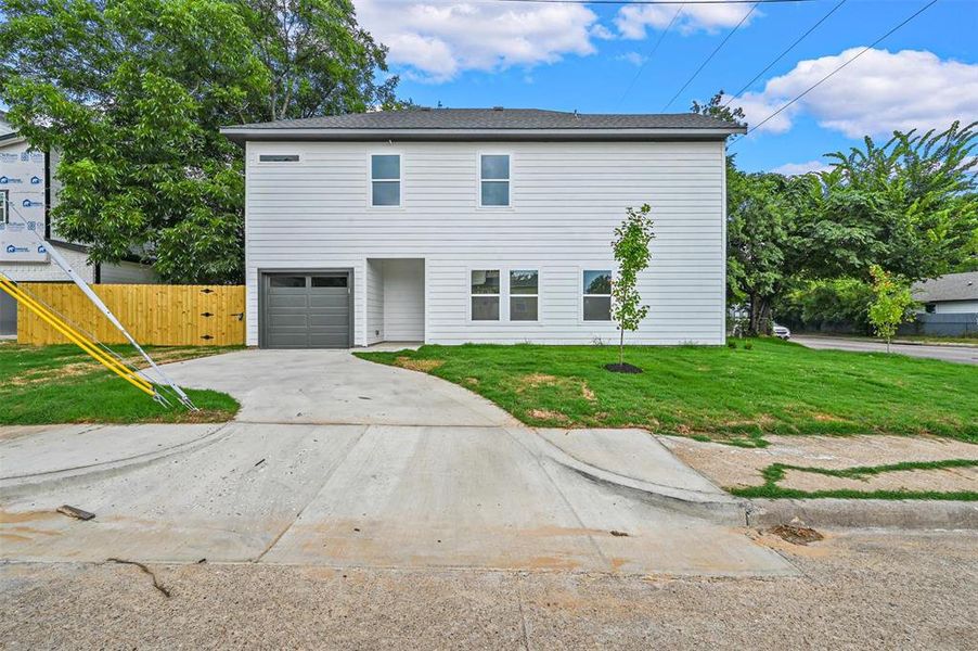 View of front of home with a garage and a front lawn