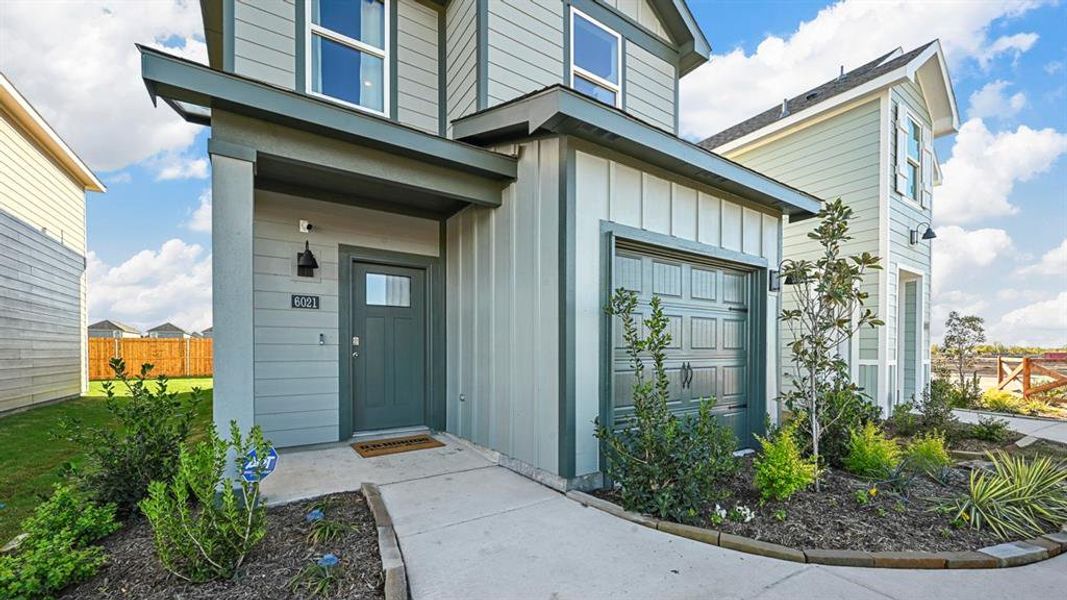 Property entrance featuring board and batten siding and a garage