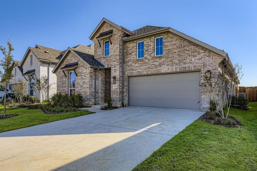 French country style house with a front yard, brick siding, concrete driveway, and a garage French country style house with a front yard, brick siding, concrete driveway, and a garage