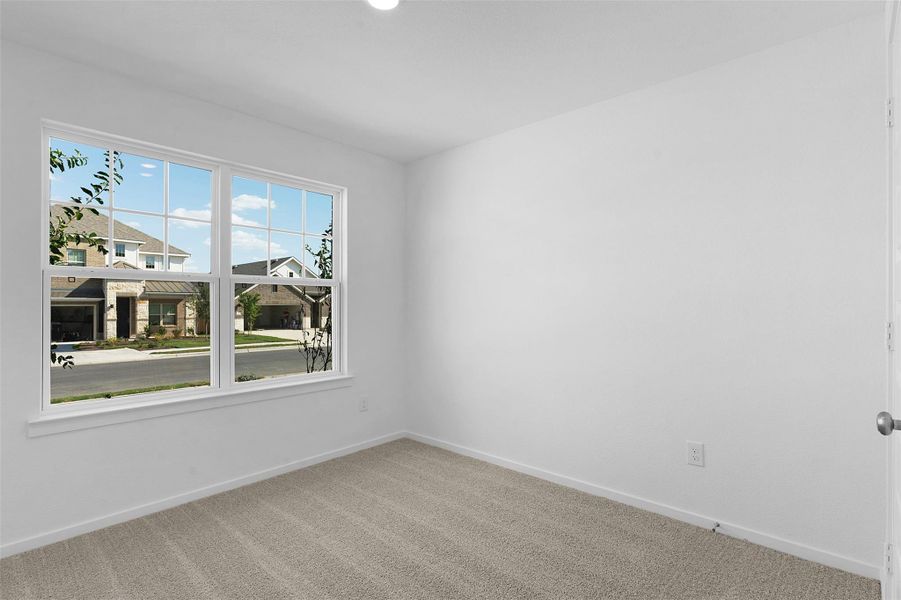 Empty room featuring light carpet and baseboards